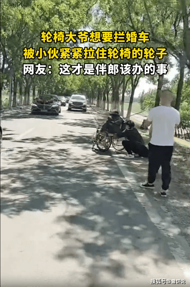 轮椅大爷想拦婚车被小伙拉住